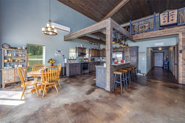 3633 Sawmill, Caddo, OK 74729 - kitchen with high vaulted ceiling, a notable chandelier, concrete flooring, a wall mounted AC, and appliances with stainless steel finishes
