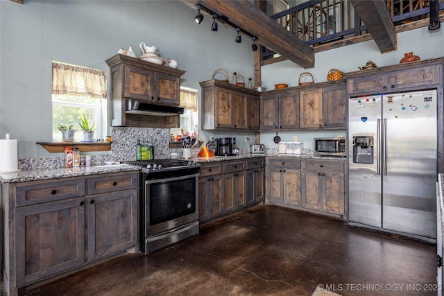 3633 Sawmill, Caddo, OK 74729 - kitchen with a high ceiling, light stone counters, under cabinet range hood, concrete flooring, and appliances with stainless steel finishes