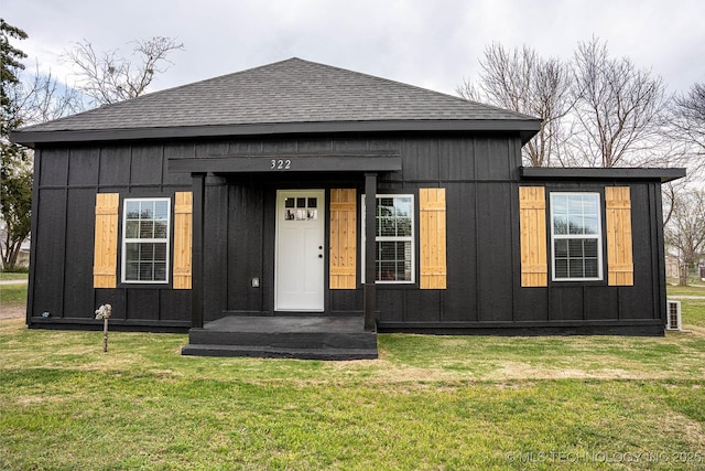 322 W Seneca St, Nowata, OK 74048 - view of front of home with board and batten siding, a shingled roof, and a front yard