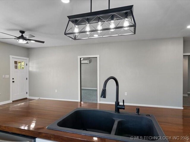 322 W Seneca St, Nowata, OK 74048 - kitchen with baseboards, a ceiling fan, wood finished floors, and a sink