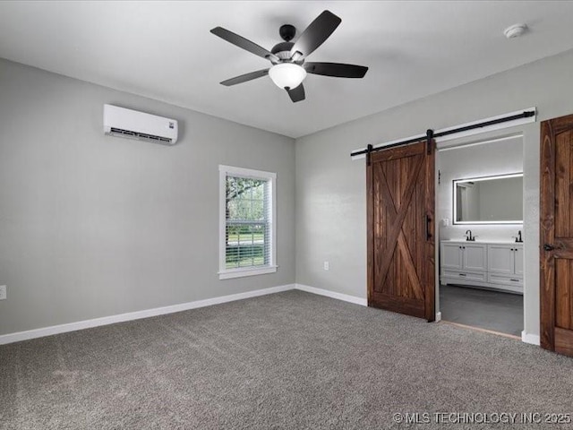 322 W Seneca St, Nowata, OK 74048 - unfurnished bedroom featuring a barn door, a wall mounted AC, baseboards, ensuite bath, and carpet flooring