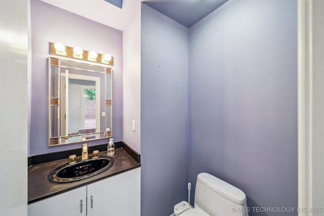 half bathroom with toilet and vanity
