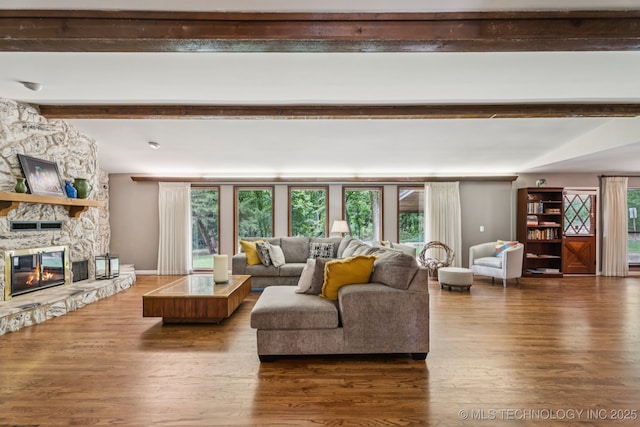 501 E Yuma Dr, Broken Arrow, OK 74011 - living area featuring healthy amount of natural light, a stone fireplace, wood finished floors, and beam ceiling