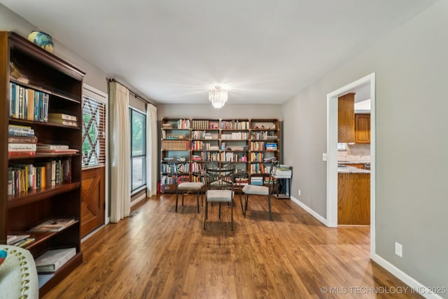 501 E Yuma Dr, Broken Arrow, OK 74011 - living area featuring wood finished floors, a chandelier, and wall of books