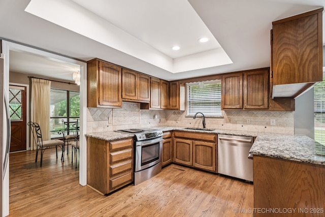 501 E Yuma Dr, Broken Arrow, OK 74011 - kitchen with appliances with stainless steel finishes, light wood finished floors, brown cabinets, light stone countertops, and recessed lighting