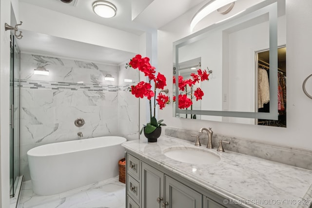 501 E Yuma Dr, Broken Arrow, OK 74011 - bathroom featuring vanity, a soaking tub, marble look tiles, tile walls, and a walk in closet