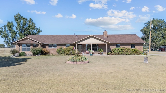 single story home with a chimney, brick siding, fence, and a front yard