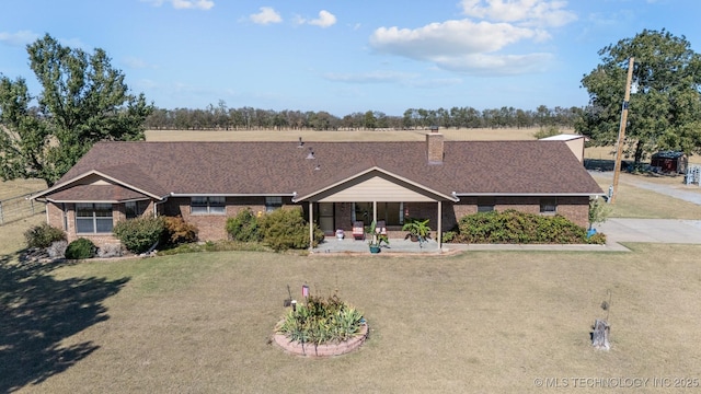 ranch-style house featuring a front lawn, brick siding, and a shingled roof