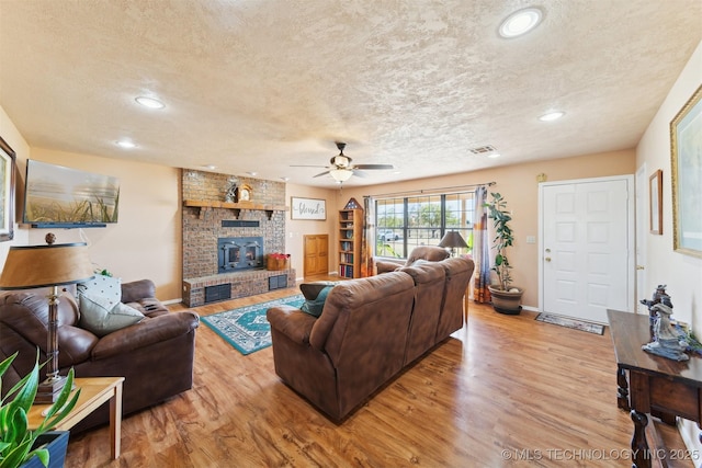 living room with a textured ceiling, recessed lighting, light wood-style floors, and ceiling fan
