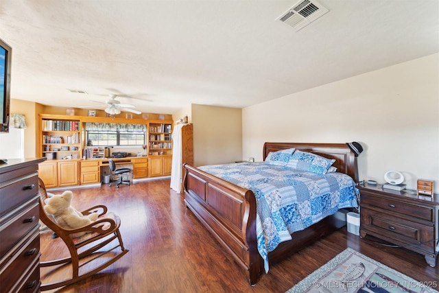bedroom with built in desk, wood finished floors, and visible vents
