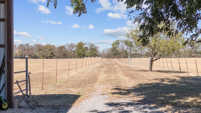 view of road with driveway, a rural view, and a gated entry