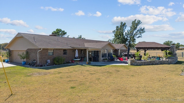back of house featuring a patio area, a gazebo, a yard, and a garage