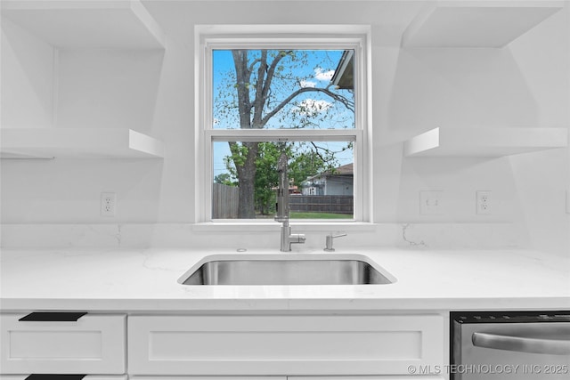 924 S Allegheny Ave, Tulsa, OK 74112 - kitchen with light stone counters, stainless steel dishwasher, white cabinetry, and a sink