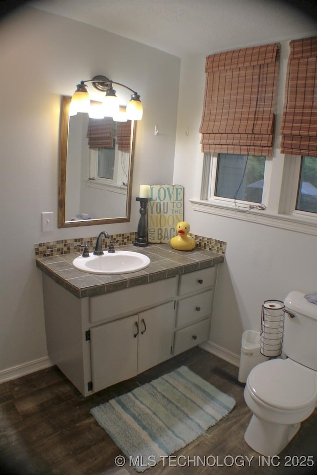 9996 N Millennium, Sulphur, OK 73086 - half bathroom featuring toilet, vanity, wood finished floors, and baseboards
