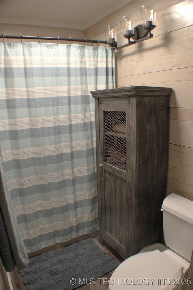 9996 N Millennium, Sulphur, OK 73086 - bathroom featuring a chandelier, wooden walls, toilet, and a shower with curtain