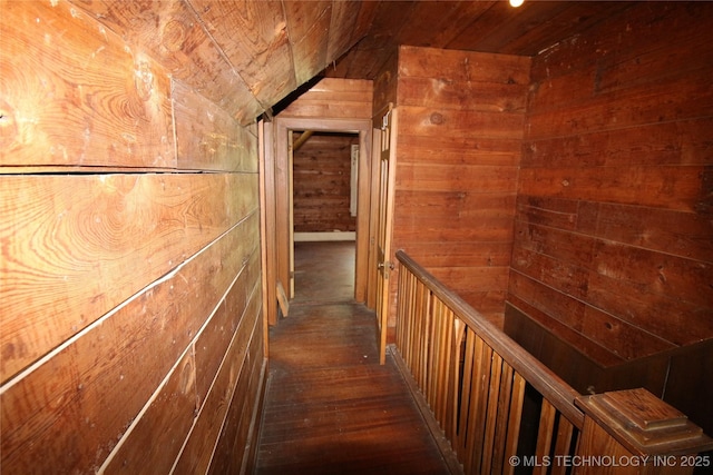 hallway featuring lofted ceiling, wooden ceiling, wood walls, and hardwood / wood-style flooring