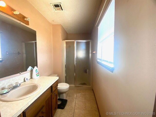 1320 Jennings St, Muskogee, OK 74403 - bathroom featuring a stall shower, vanity, a textured ceiling, tile patterned flooring, and toilet