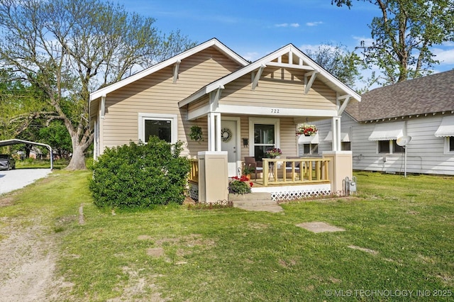 722 S Hughes Ave, Morris, OK 74445 - view of front of home with a porch, a front lawn, and a carport