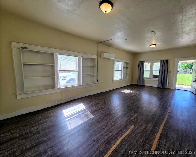 602 N Collins Ave, Okmulgee, OK 74447 - spare room featuring baseboards, a wall unit AC, and dark wood-style flooring