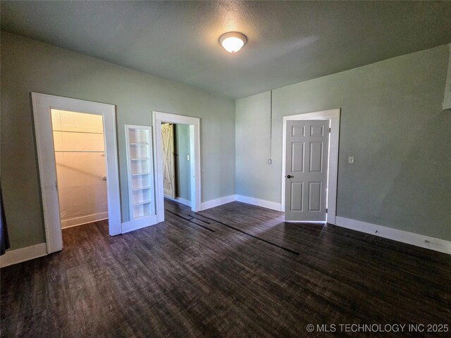 602 N Collins Ave, Okmulgee, OK 74447 - spare room featuring baseboards and dark wood-type flooring