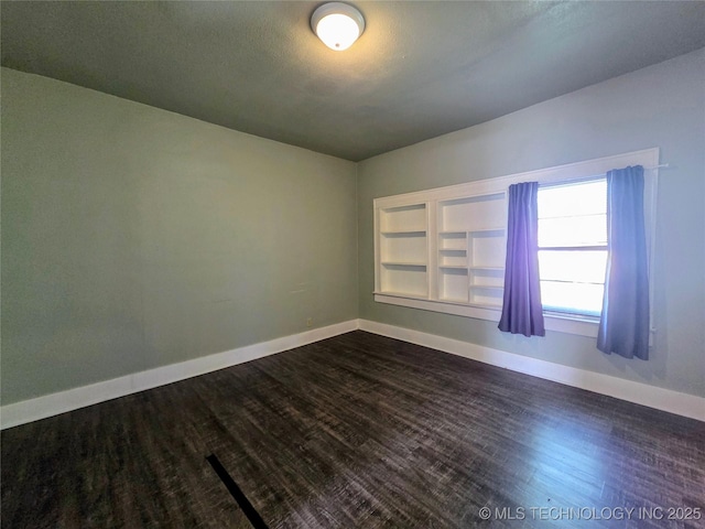 602 N Collins Ave, Okmulgee, OK 74447 - unfurnished room featuring baseboards, dark wood finished floors, and built in features