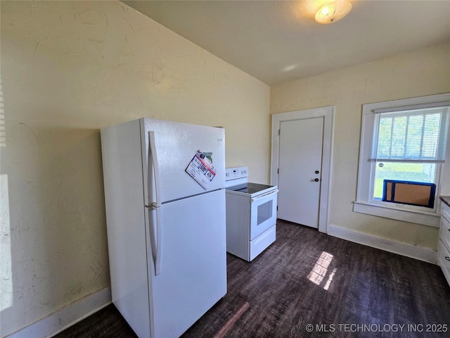 602 N Collins Ave, Okmulgee, OK 74447 - kitchen featuring dark wood-style flooring, baseboards, lofted ceiling, white appliances, and white cabinetry