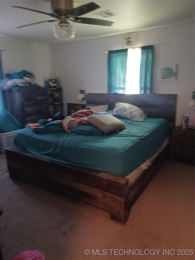 bedroom featuring crown molding, carpet floors, visible vents, and a ceiling fan