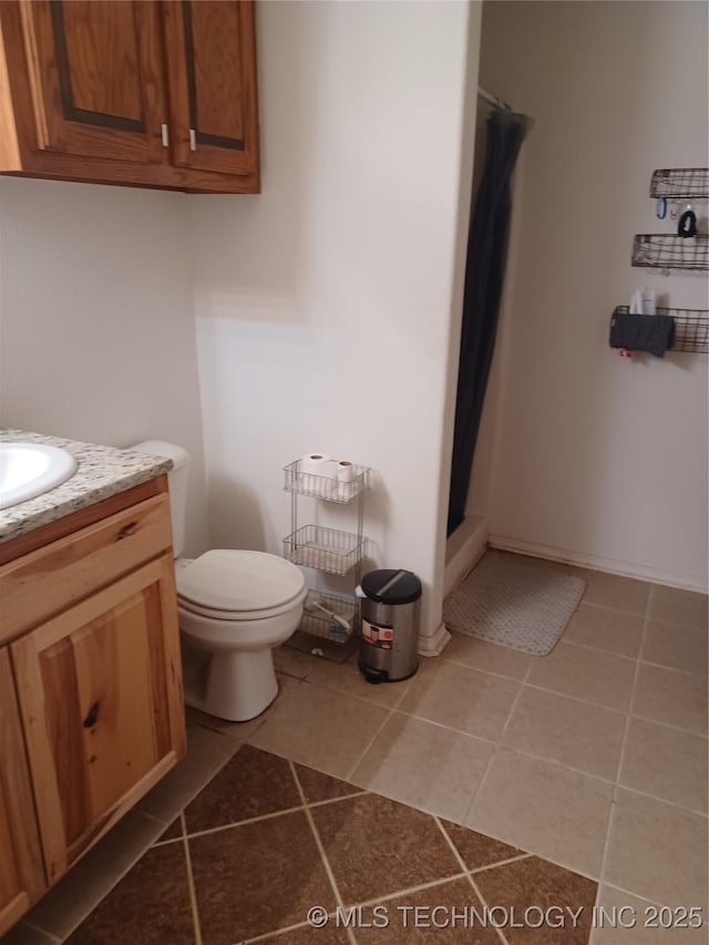 bathroom featuring a shower with shower curtain, tile patterned flooring, vanity, and toilet