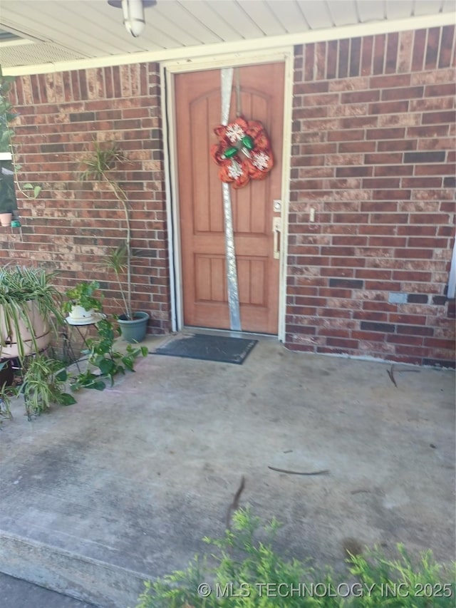 doorway to property with brick siding