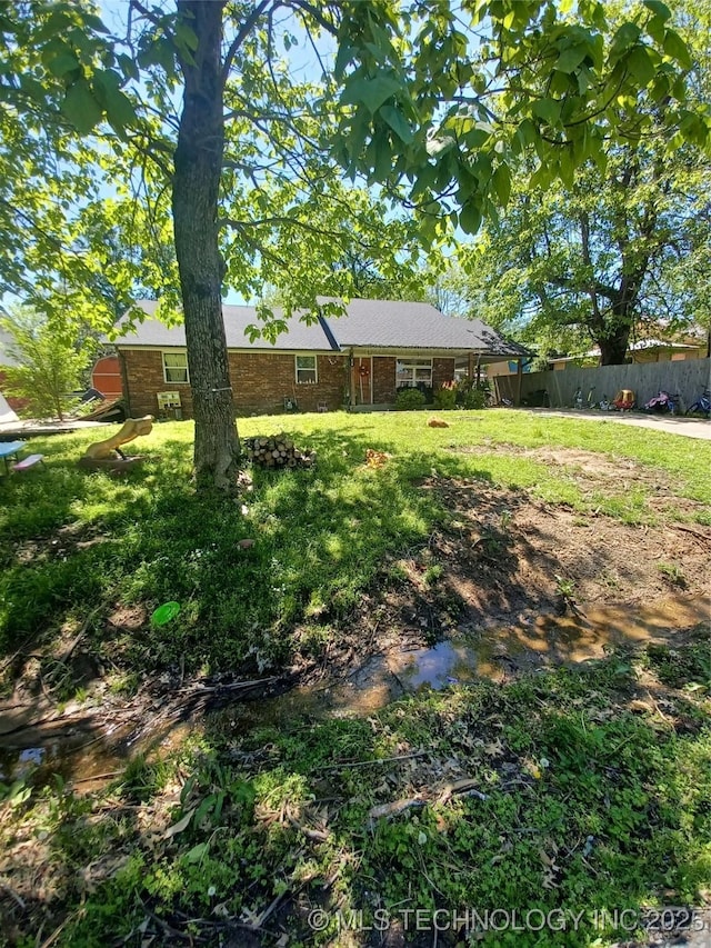 view of front of house with a front lawn and fence