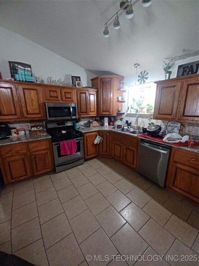 kitchen featuring decorative backsplash, brown cabinetry, and appliances with stainless steel finishes