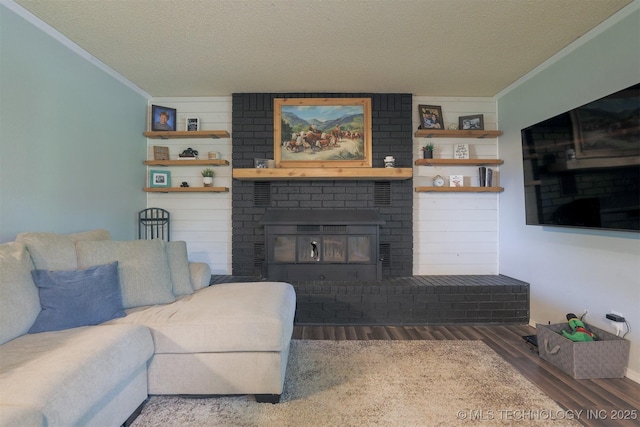 1414 N Eagle Rd, Yale, OK 74085 - living area with ornamental molding, a brick fireplace, a textured ceiling, and wood finished floors