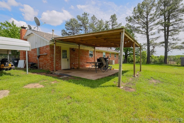 1414 N Eagle Rd, Yale, OK 74085 - rear view of house featuring a lawn, a patio area, brick siding, and a chimney
