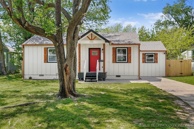 view of front of house with fence, crawl space, a front lawn, and board and batten siding