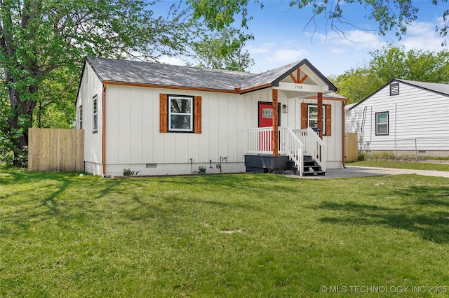 view of front of property with fence, crawl space, a shingled roof, and a front lawn