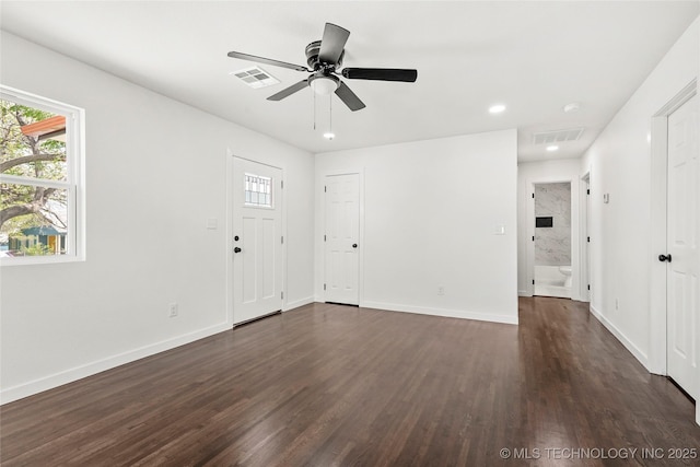 unfurnished living room with visible vents, dark wood finished floors, and a healthy amount of sunlight