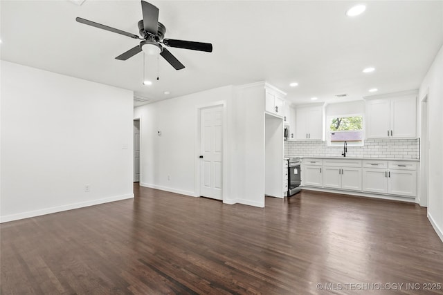 unfurnished living room with recessed lighting, ceiling fan, a sink, baseboards, and dark wood-style flooring