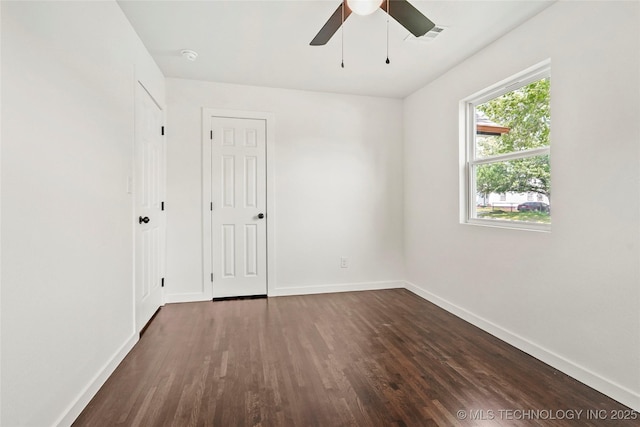 empty room with ceiling fan, baseboards, and dark wood-style floors