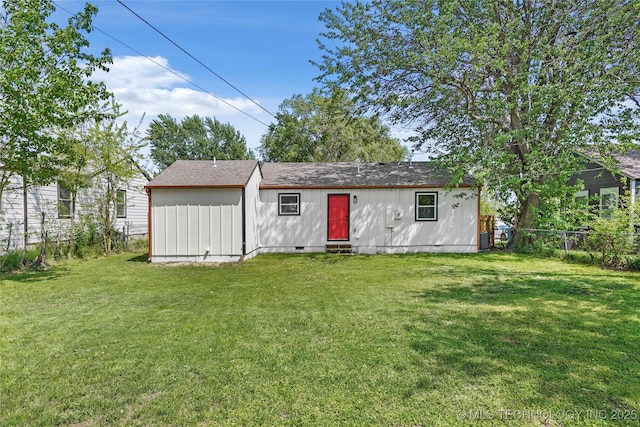 rear view of property with fence, crawl space, entry steps, and a yard
