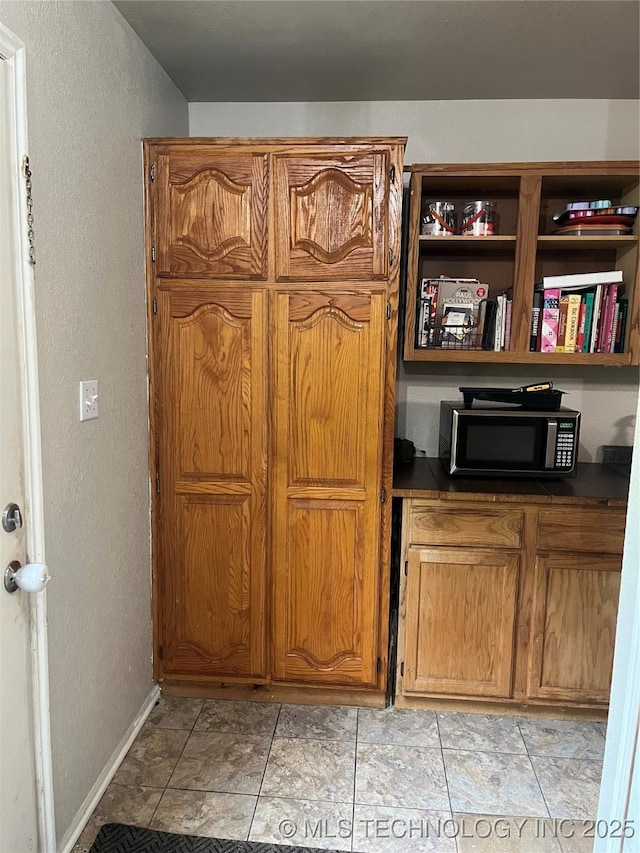 27121 E 161st St S, Coweta, OK 74429 - detailed view of stainless steel microwave, baseboards, and a textured wall