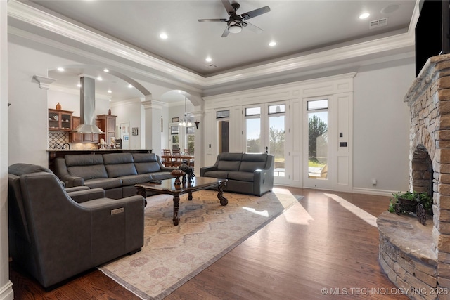 5905 W Charleston St, Broken Arrow, OK 74011 - living area with dark wood-style floors, a ceiling fan, ornamental molding, arched walkways, and decorative columns