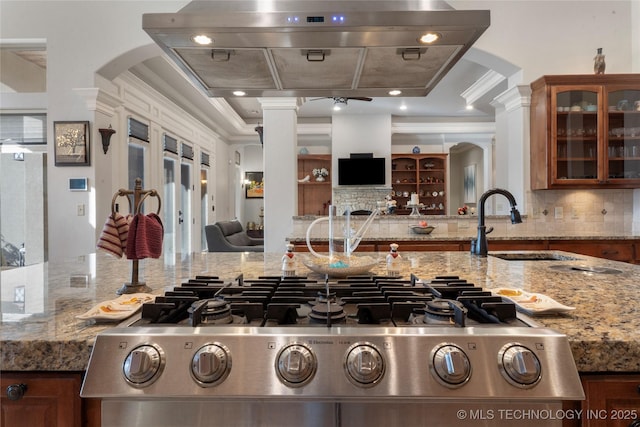 5905 W Charleston St, Broken Arrow, OK 74011 - kitchen with arched walkways, brown cabinetry, open floor plan, and decorative columns