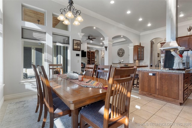 5905 W Charleston St, Broken Arrow, OK 74011 - dining room featuring ornate columns, light tile patterned floors, arched walkways, crown molding, and ceiling fan