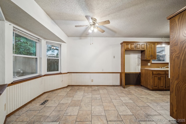 3316 S Ash Pl, Broken Arrow, OK 74012 - spare room with ceiling fan, a sink, a textured ceiling, a wainscoted wall, and visible vents
