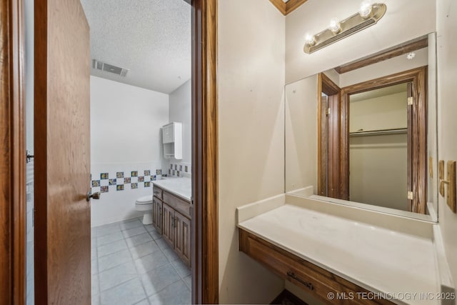 3316 S Ash Pl, Broken Arrow, OK 74012 - bathroom with visible vents, vanity, toilet, tile walls, and tile patterned floors