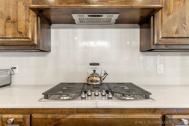 4416 S Orange Ave, Broken Arrow, OK 74011 - kitchen with dark brown cabinetry, light countertops, stainless steel gas stovetop, and ventilation hood