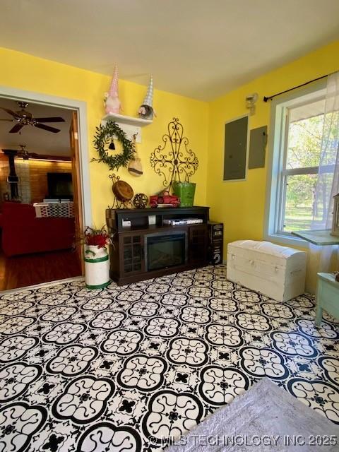 living room with a ceiling fan and electric panel
