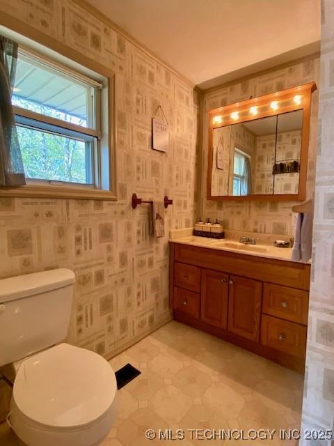 bathroom featuring vanity, visible vents, toilet, and wallpapered walls