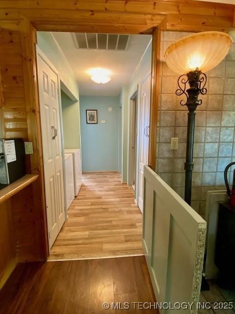 hall with visible vents and wood finished floors