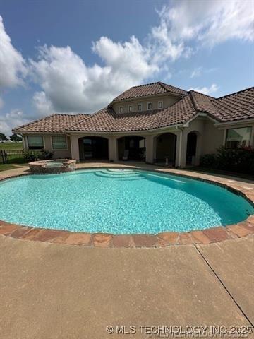 view of swimming pool featuring a pool with connected hot tub and a patio